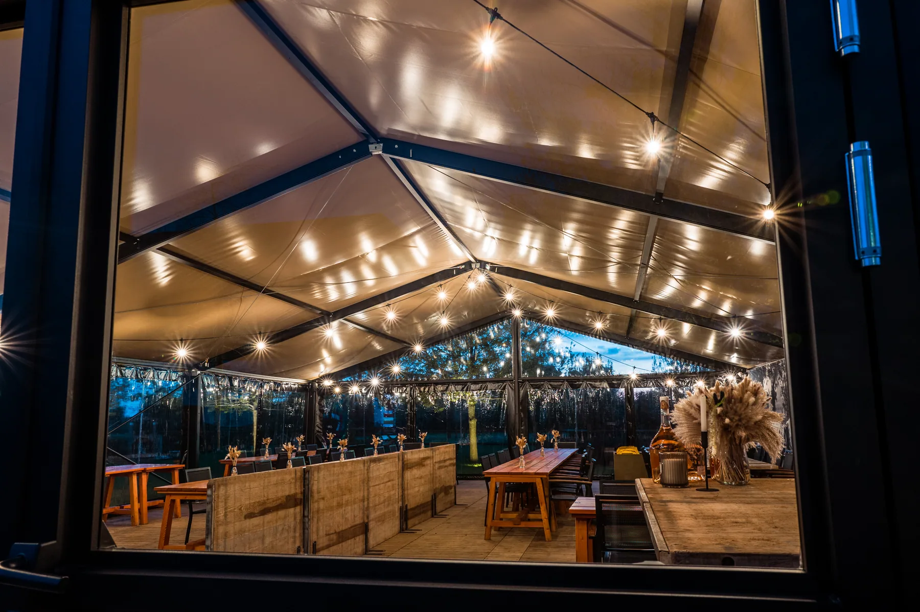 Binnenzicht luxe kadertent met zwart frame en lichtslingers