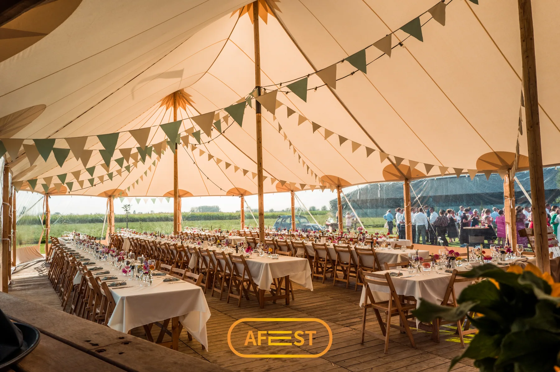 Lange gedekte tafels onder een sailcloth tent